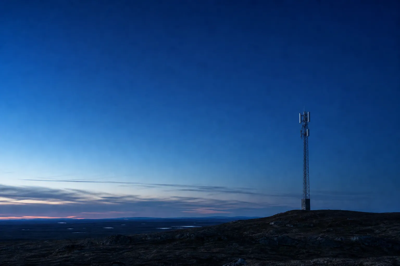Telekommast i ett nordiskt landskap i skymning